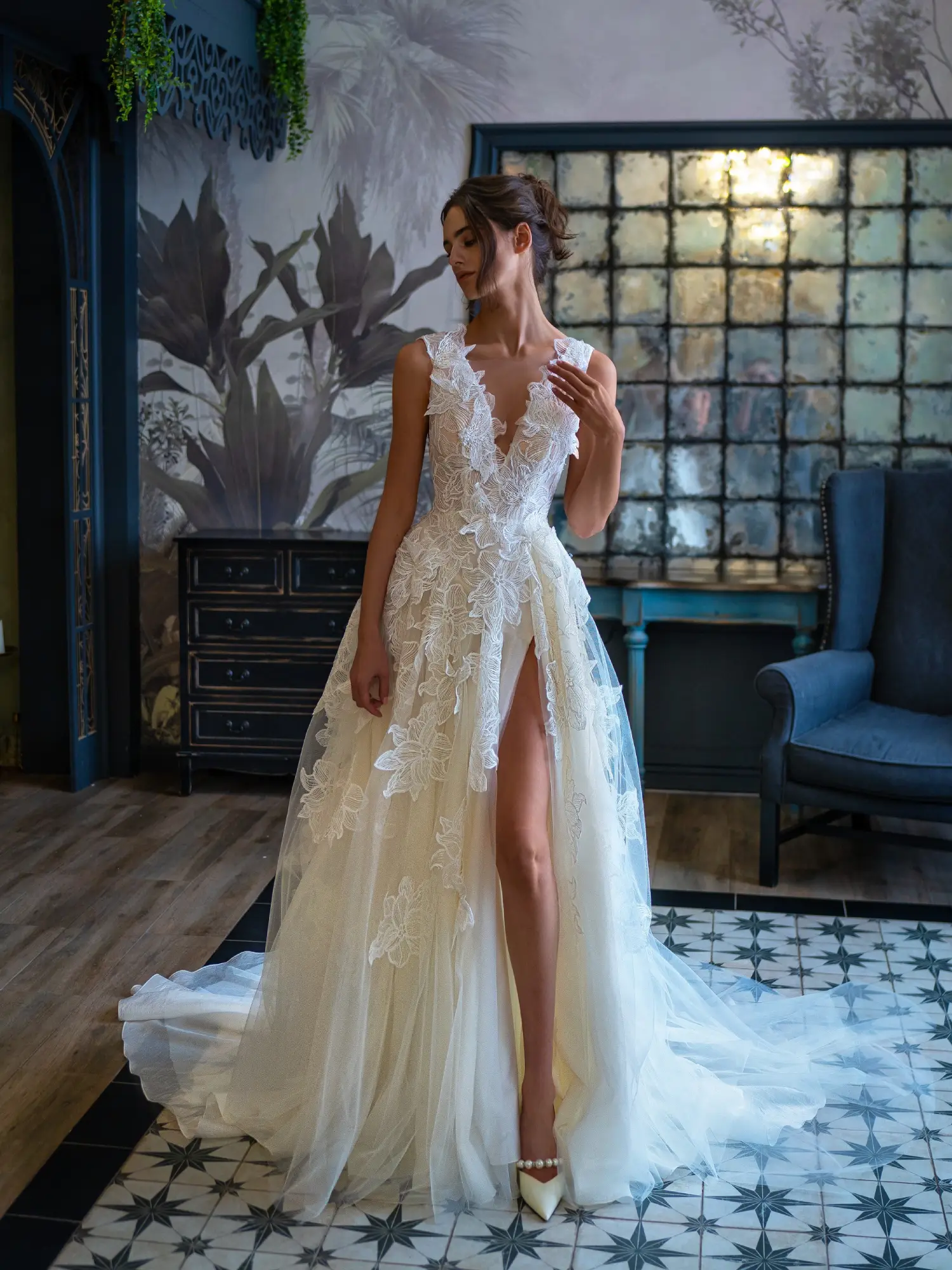 Elegant bride in a deep V-neck floral lace wedding dress, standing in a luxurious room at Papilio Boutique, a leading bridal store in Toronto.