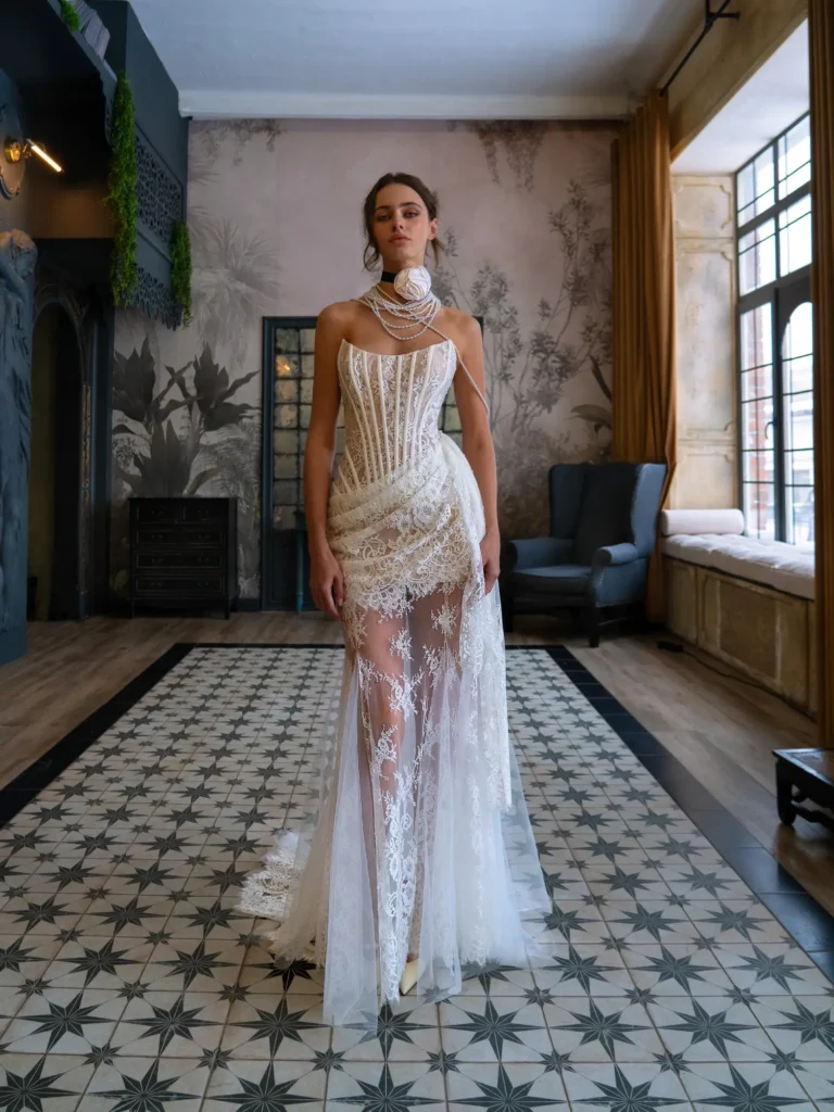 Bride wearing a sheer lace wedding dress with a corset bodice, walking through a vintage-inspired room at Papilio Boutique in Toronto.