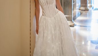 Elegant drop waist wedding dress with a corset-style bodice and intricate lace details, showcased in a grand hall setting at Papilio Boutique in Toronto.