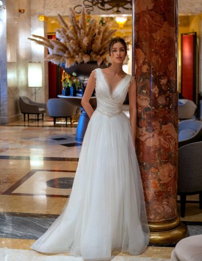 Elegant pearl-embellished wedding gown in a luxurious hotel lobby, by Papilio Boutique Toronto.