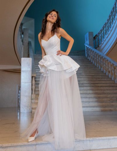 Model in a transformer wedding dress, transitioning from mini to full-length with a detachable skirt at Papilio Boutique.