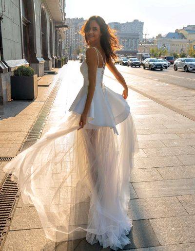 Model in a transformer wedding dress, transitioning from mini to full-length with a detachable skirt at Papilio Boutique.