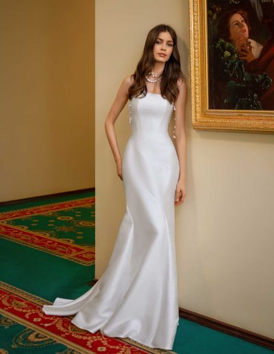 Elegant profile of a fitted wedding gown with accent flower and pearl necklace, photographed at Papilio Boutique Toronto bridal store.