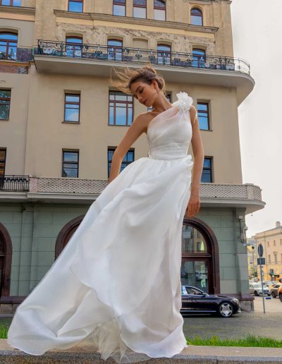 Bride in romantic organza wedding dress with one-shoulder floral detail, by Papilio Boutique Toronto bridal store.