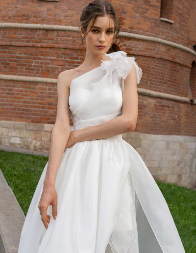 Close-up of a one-shoulder wedding dress with organza floral details, by Papilio Boutique Toronto bridal store.