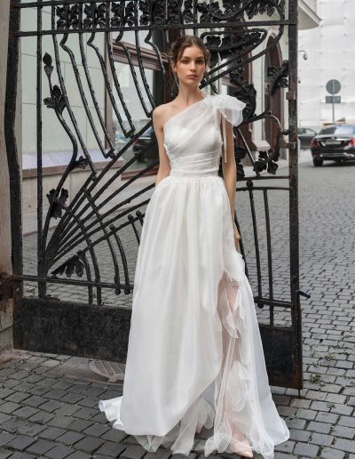 Stylish bride walking in an organza wedding gown with detailed shoulder design, by Papilio Boutique Toronto bridal store.