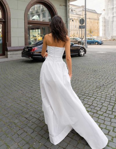 Back view of a strapless wedding gown with a sleek silhouette and open leg, by Papilio Boutique Toronto bridal store.