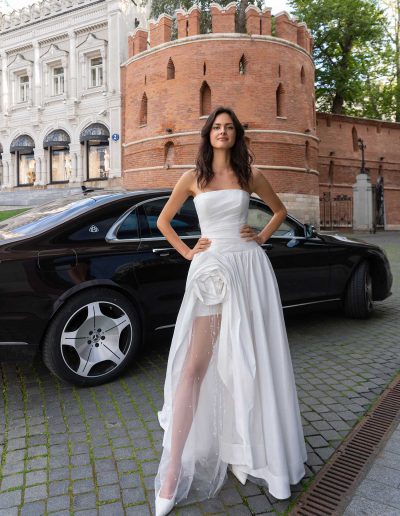 Full view of a bride in a strapless wedding dress showcasing a bold leg slit, by Papilio Boutique Toronto bridal store.