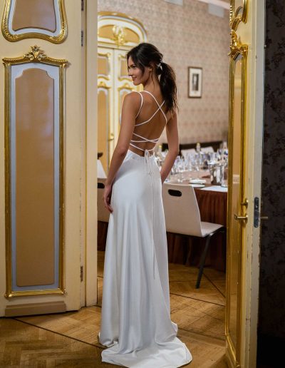 Rear view of a bride in a slip wedding gown with intricate back details, by Papilio Boutique Toronto bridal store.