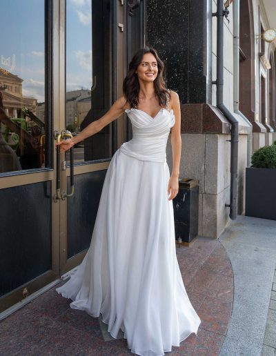 Bride smiling in a lightweight organza wedding gown with spaghetti straps, ideal for a summer wedding, by Papilio Boutique Toronto bridal store.