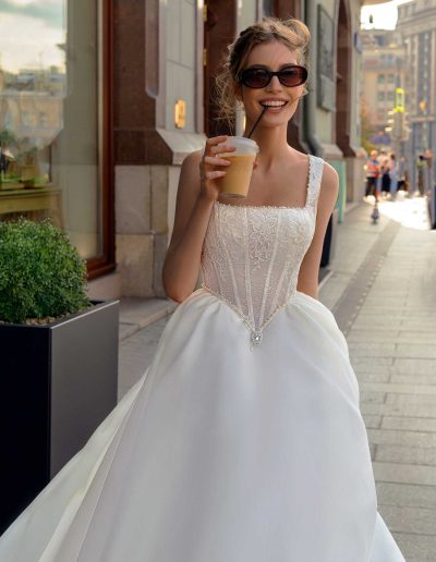 Bride in a basque waist wedding dress with lace details, enjoying a casual moment, by Papilio Boutique Toronto bridal store.