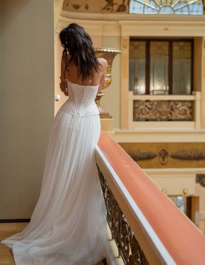 Back view of a trendy wedding dress with corset and pleated skirt by Papilio Boutique Toronto, highlighting intricate designs.