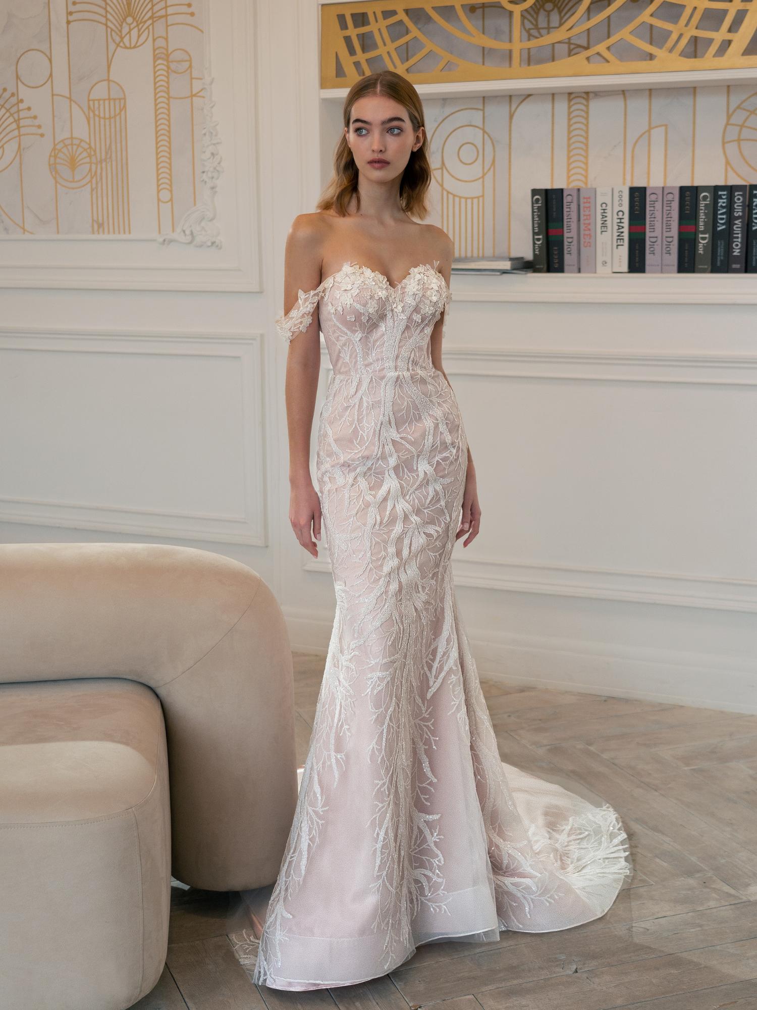 Romantic off-the-shoulder mermaid wedding dress with intricate lace embroidery, a structured corset bodice, and a soft blush hue, ideal for petite brides seeking a figure-flattering silhouette. The Best Wedding Dress for Body Type - Petite is available at Papilio Boutique in Toronto.