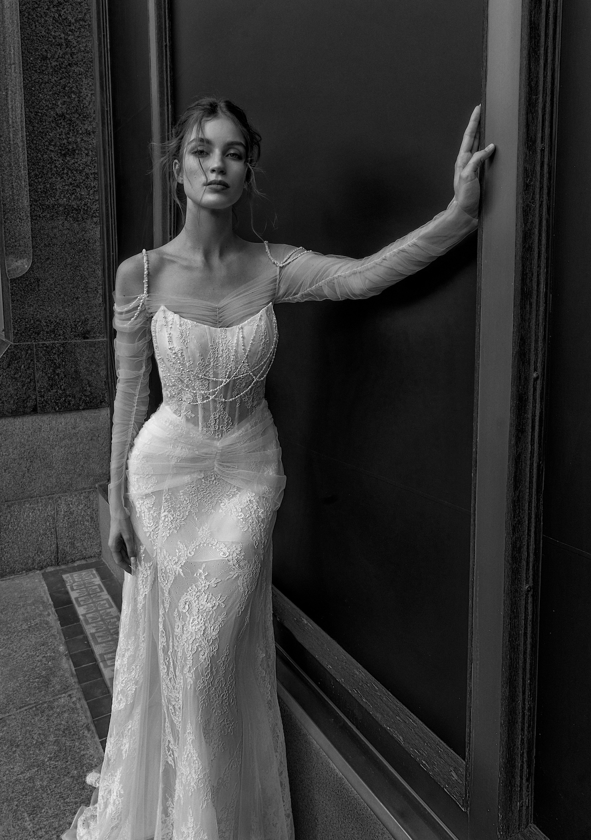 A sophisticated drop waist wedding dress with long lace sleeves and a form-fitting bodice, representing the timeless elegance of drop waist wedding dresses available at Papilio Boutique in Toronto.