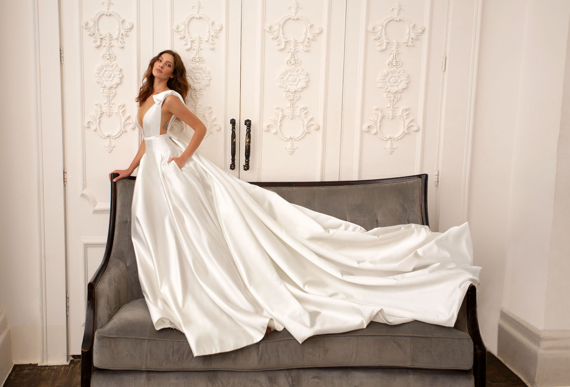 Bride wearing a sleek satin gown with a dramatic train and modern cutout details, showcasing the elegance of modern wedding dresses.