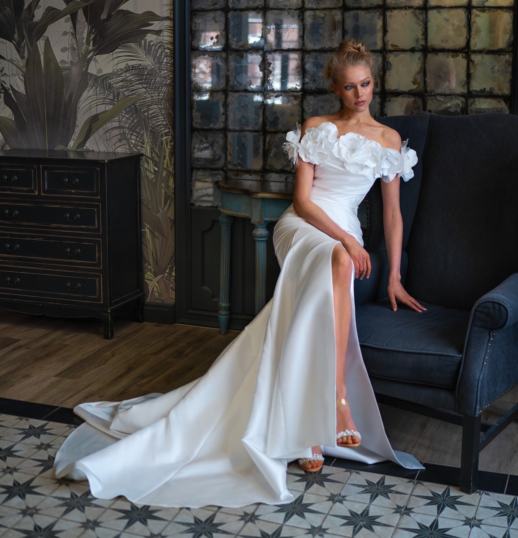 Sophisticated satin wedding dresses with a sleek silhouette, featuring off-shoulder design adorned with large white flowers, perfect for a bride looking for a unique style in Toronto.